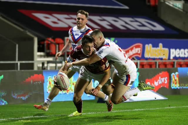 Huddersfield Giants' Sam Wood is tackled by Wakefield Trinity's Max Jowitt short of the try-line on Thursday night. Picture: Martin Rickett/PA Wire.