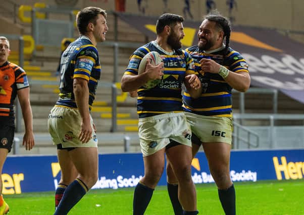 Rhyse Martin celebrates scoring Leeds Rhinos' fifth try against Castleford with Konrad Hurrell and Luke Briscoe. Picture: Bruce Rollinson.