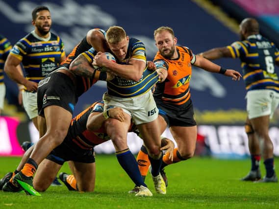 Leeds Rhinos' Mikolaj Oledzki, playing his second game in four days, is tackled by Castleford Tigers' Paul McShane, who also backed up from last week. Picture by Bruce Rollinson.
