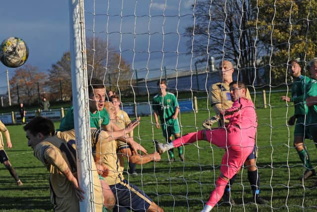 Ilkley goalkeeper Tim Edney punches clear under pressure from hosts Beeston St Anthony's. Picture: Steve Riding.