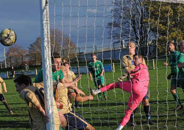 Ilkley goalkeeper Tim Edney punches clear under pressure from hosts Beeston St Anthony's. Picture: Steve Riding.