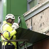 A workman in Sheffield replaces cladding on a block of flats. (Pic: SWNS)