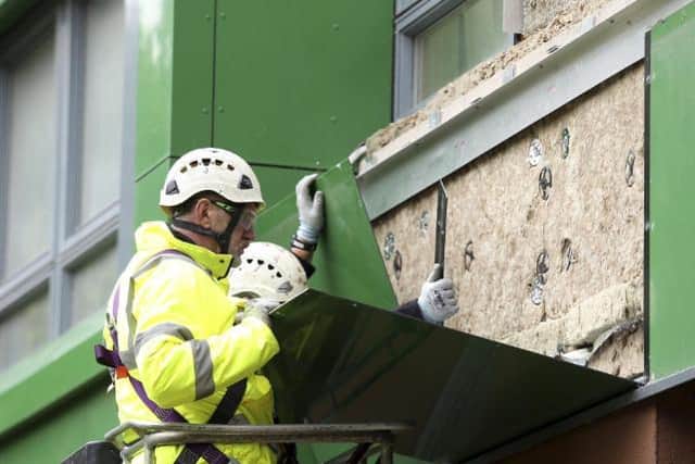 A workman in Sheffield replaces cladding on a block of flats. (Pic: SWNS)