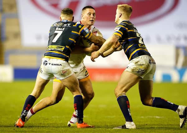 Under fire: Catalans Dragons' Joel Tomkins (centre) is tackled by Leeds Rhinos' Luke Gale (left) and Alex Sutcliffe during the Betfred Super League Play-Off match Picture: Zac Goodwin/PA Wire.