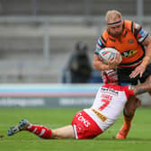 Oliver Holmes is tackled by St Helens' Theo Fages. Picture by Bruce Rollinson.