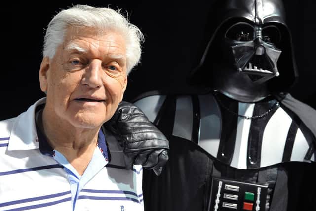 David Prowse (left) who played the character of Darth Vader in the first Star Wars trilogy poses with a fan dressed up in a Darth Vader costume during a Star Wars convention in April 2013.
