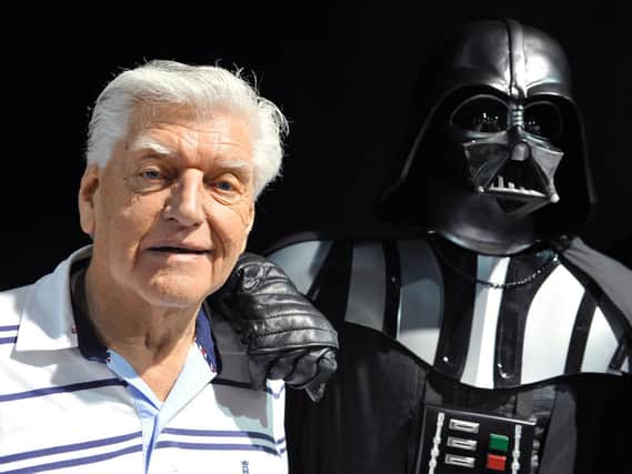 David Prowse (left) who played the character of Darth Vader in the first Star Wars trilogy poses with a fan dressed up in a Darth Vader costume during a Star Wars convention in April 2013.