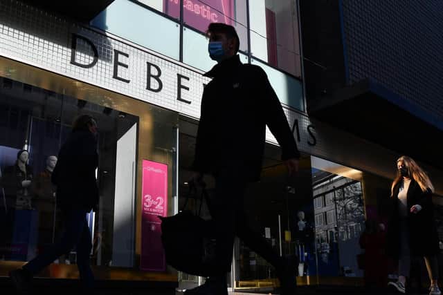 Pedestrians walk past a Debenhams department store in London on December 1, 2020, as non-essential retail prepares to re-open its doors to the public on December 2 following a second national lockdown to help stem the spread of the novel coronavirus. Photo by JUSTIN TALLIS/AFP via Getty Images)