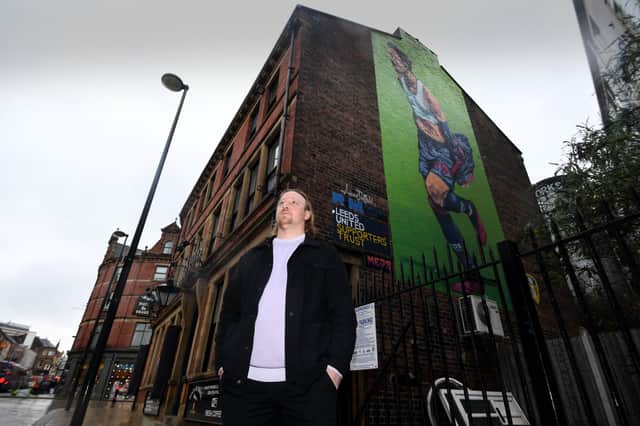 Artist Adam Duffield pictured with his Pablo Hernandez mural on the side of the Duck and Drake pub in the city centre. Picture by Simon Hulme.