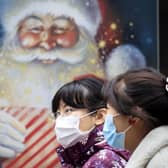 People walk past a Christmas display in a shop window in Leeds in November. Picture: Danny Lawon/PA Wire