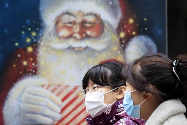 People walk past a Christmas display in a shop window in Leeds in November. Picture: Danny Lawon/PA Wire
