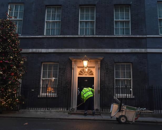A man cleans the street in front of 10 Downing Street (photo: PA).