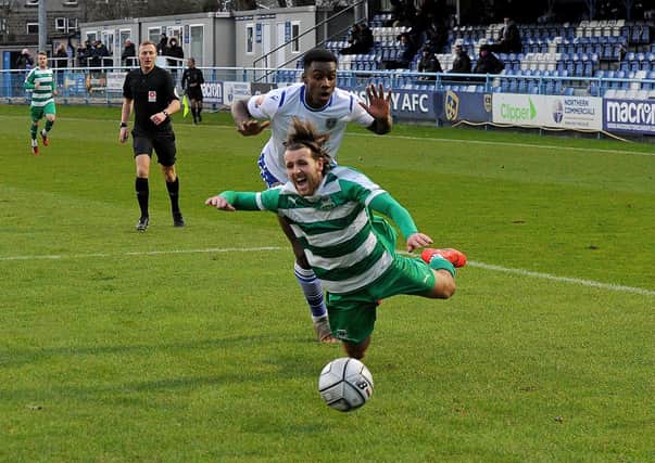 Luke Parkin of Farsley Celtic is brought down by 
Chukwudalu Molokwu of Guiseley for a penalty. Picture: Steve Riding.