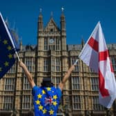 File photo dated 25/06/18 of an anti-Brexit demonstrator holding European Union and England flags outside the Houses of Parliament, in central London. The UK and EU have reached a post-Brexit trade agreement (photo: PA).