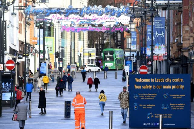 The scene yesterday in Briggate where signs remind visitors to Leeds city centre about the latest Covid restrictions. Picture: Simon Hulme