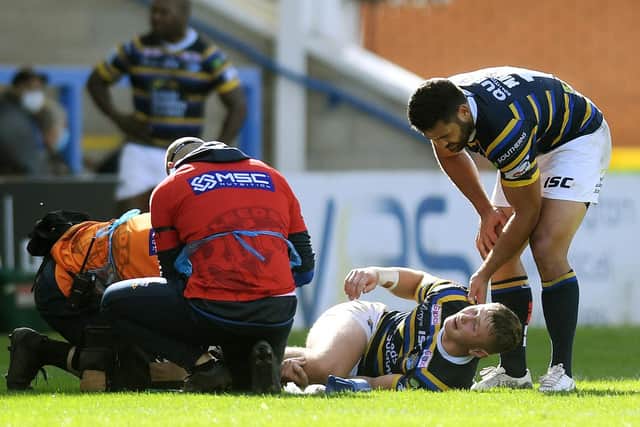 Harry Newman is comforted by teammate Rhyse Martin as he receives treatment on the pitch last September. Picture by Jonathan Gawthorpe.
