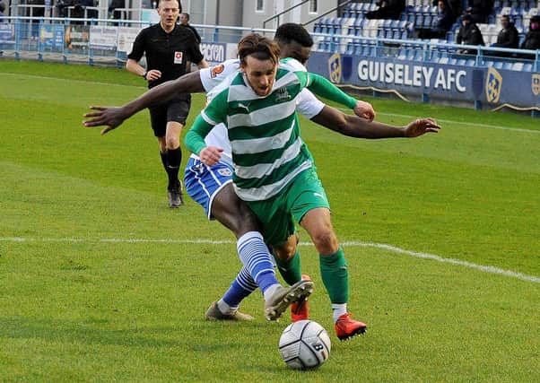 Luke Parkin of Farsley Celtic is brought down by Guiseley defender Chukwudalu Molokwu for a penalty during the Boxing Day clash between the sides at Nethermoor. Picture: Steve Riding.