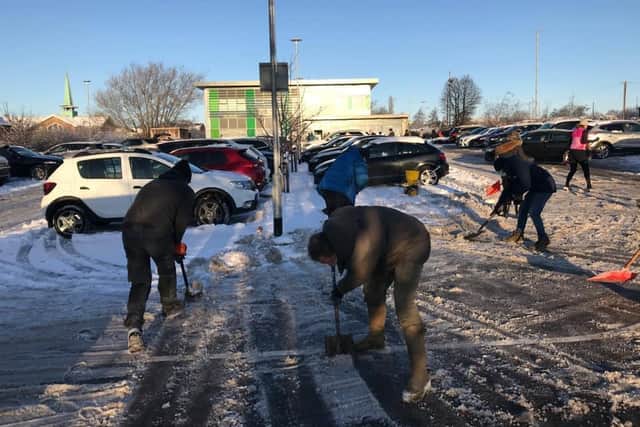 Volunteers clear the snow outside Alwoodley Medical Centre.