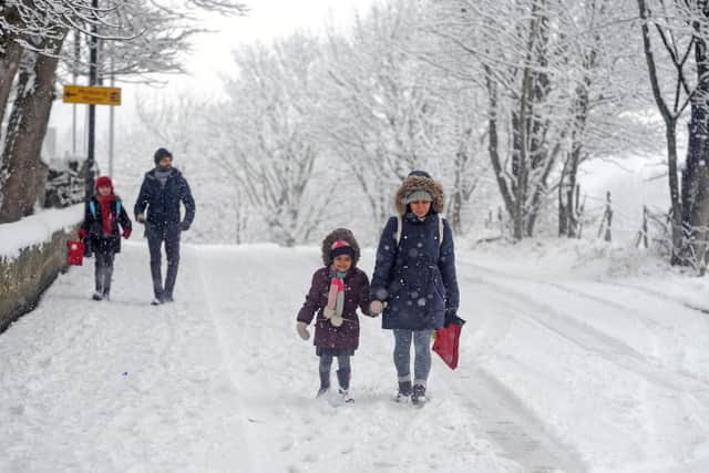 A parent taking their child to school in the snow in Farsley in 2018.