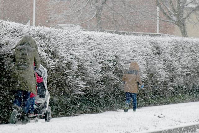 A family walks in the snow in Whitkirk on Thursday