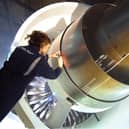 Rolls-Royce photo of a female worker inspecting a Trent 1000 engine.