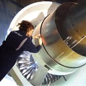 Rolls-Royce photo of a female worker inspecting a Trent 1000 engine.