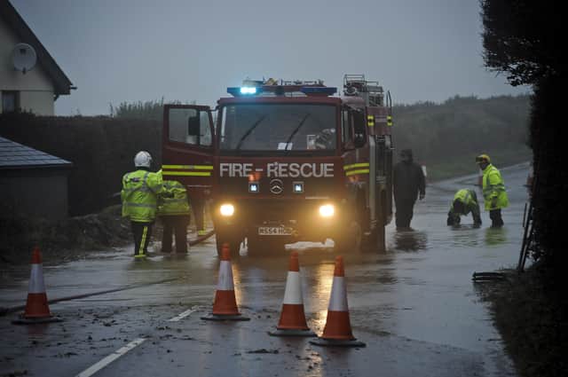 Fire and Rescue services work to clear a section of the A399 in North Devon, where severe weather is causing havoc in the north of the County with many roads impassable and widespread flooding.