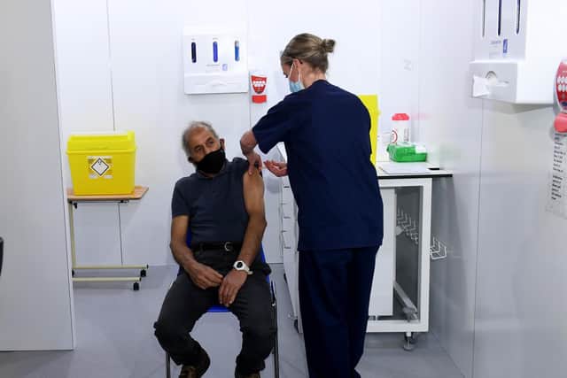 Leeds women's player and nurse Olivia Smart gives 72-year-old Mewa Singh Khala his vaccination.