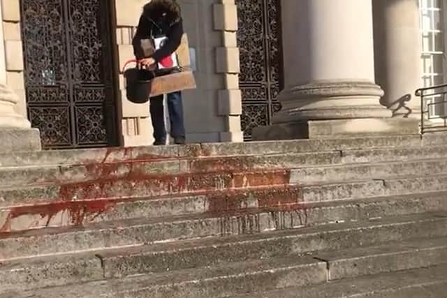 Extinction Rebellion protesters throwing fake 'blood' on the steps of Leeds Civic Hall.