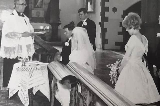 Glenis and her husband Anthony being married in the church by a priest.