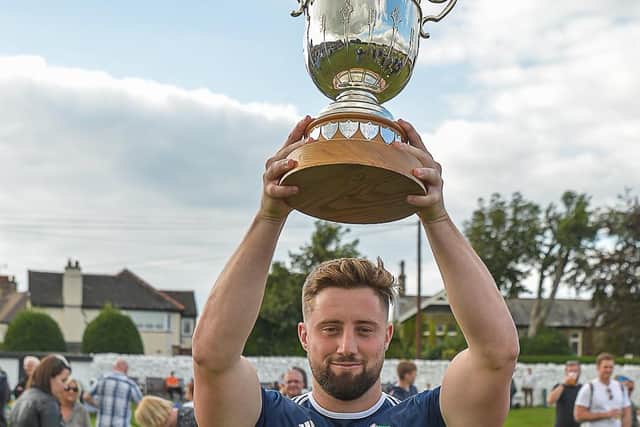It's ours: Hanging Heaton's Ben Kholer-Cadmore lifts the Bradford League T20 trophy after victory over Bradford & Bingley last season. Picture: Ray Spencer