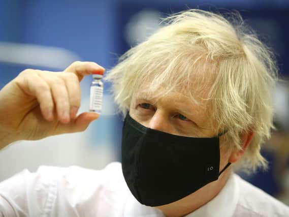 Boris Johnson holding a vial of the Oxford/Astra Zeneca Covid-19 vaccine. Picture:  Geoff Caddick/PA Wire