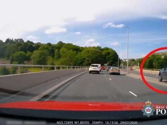 Dash cam footage of car overtaking slowing traffic by driving into the path of oncoming traffic on the wrong carriageway