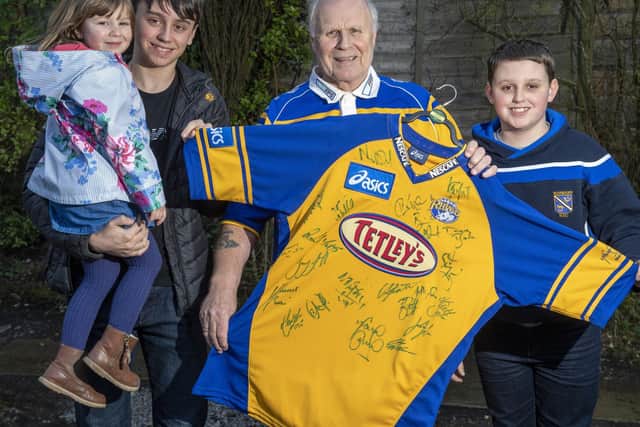 Steve Todd, pictured with grandchildren Isobel, Matthew and Luke, holds up the signed Leeds Rhinos shirt being sold to raise funds for the Motor Neurone Disease Association. Picture: Bruce Rollinson