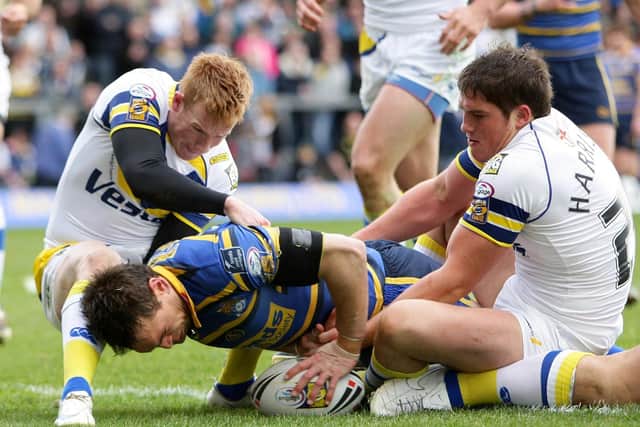 Leeds Rhinos captain Kevin Sinfield goes over for a try as Warrington's Chris Riley (left) and Ben Harrison try and stop him. Picture: Martin Rickett/PA Wire.