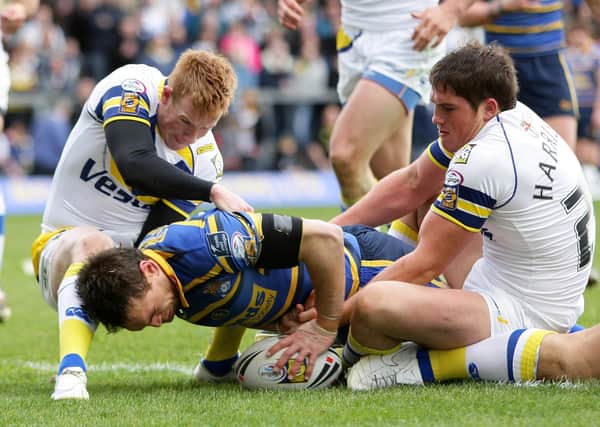 Leeds Rhinos captain Kevin Sinfield goes over for a try as Warrington's Chris Riley (left) and Ben Harrison try and stop him. Picture: Martin Rickett/PA Wire.