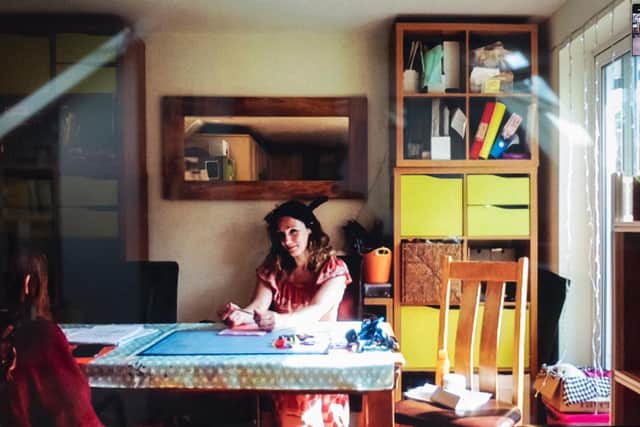 Bianca, who had been furloughed from her job, sitting at the kitchen table with her middle daughter in the sunlight. Picture: Fran Monks