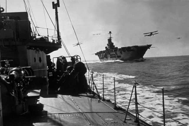 circa 1941: HMS Ark Royal on patrol, with planes flying around her deck, seen from an accompanying destroyer. (Photo by Keystone/Getty Images)
