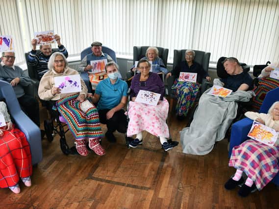 Residents at Moorleigh Nursing Home in Kippax with drawings by children at Little Learners Nursery.
Residents are pictured with activities coordinator Oona-mai Sharp.
Picture : Jonathan Gawthorpe