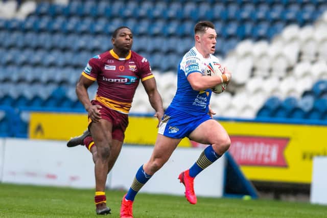 Jack Broadbent held off Jermaine McGillvary to score a long-range try for Rhinos at Huddersfield. Picture by Tony Johnson.