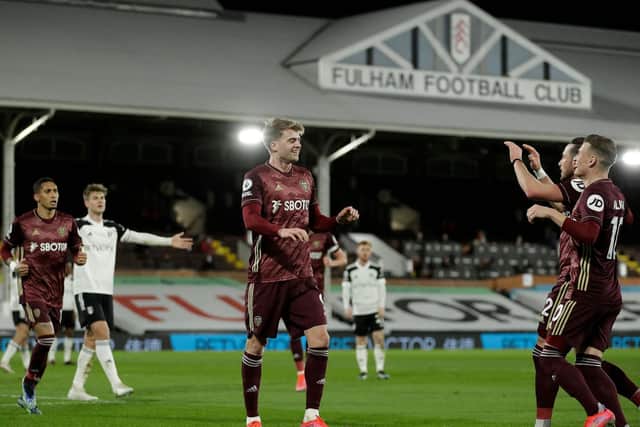 TEAM EFFORT: Leeds United striker Patrick Bamford heads to celebrate with his Whites colleagues including Jack Harrison and Gjanni Alioski, right, after scoring the opener at Fulham. Photo by MATT DUNHAM/POOL/AFP via Getty Images.