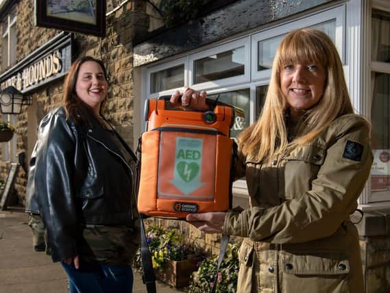 Louisa Pouncett, WF3 Kindness Volunteer, and Camille Leach, secretary for West Ardsley Action Group with the defibrillator at the Hare and Hounds in West Ardsley. Picture: Bruce Rollinson
