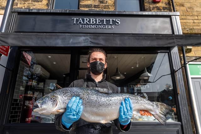 Staff member Henry O'Loughlin, holding a whole Salmon outside Tarbett's Fishmongers in Chapel Allerton. Photo: James Hardisty