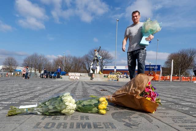 A man lays a floral tribute outside Elland Road in Leeds, following the death of Leeds' all-time record goalscorer Peter Lorimer (Photo: Danny Lawson/PA Wire)