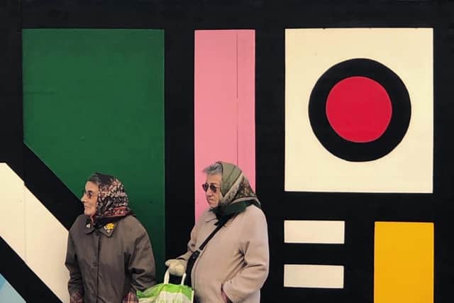 Two women wait for the bus at a stop which artist Ben Craven has turned into a colourful work of art. Photo provided by artist.