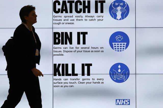 An NHS catch it, bin it, kill it sign on TV screens in the entrance to the QEII Centre in London (Photo: Philip Toscano/PA Wire)