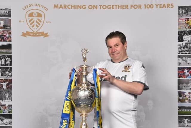 Leeds United fan Dave Tomlinson pictured with the 2019/20 Sky Bet Championship trophy.