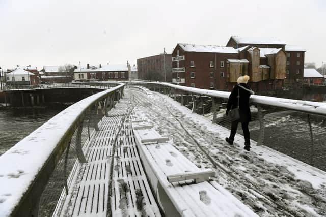 A yellow ice warning has been issued for Leeds. Pictured: A woman walks across the Millennium Bridge in Castleford in 2021.