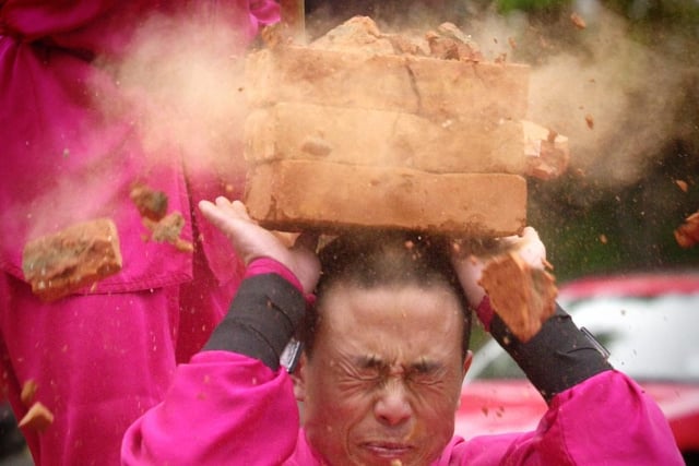 Members of the Chinese State Circus perform their rock breaking act at Little London in May 2002.