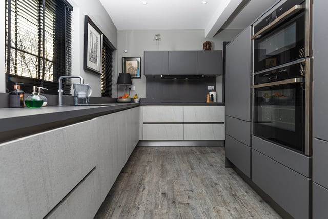 Fitted units and appliances line the walls of the stylish kitchen.